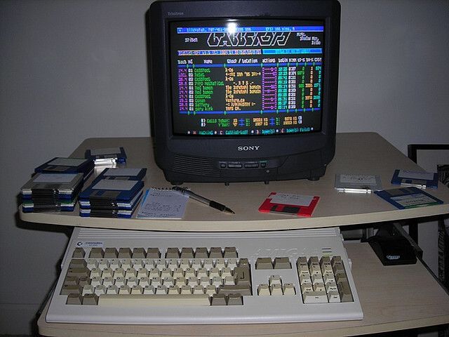 Amiga computer connected to a CRT showing a colorful BBS menu screen